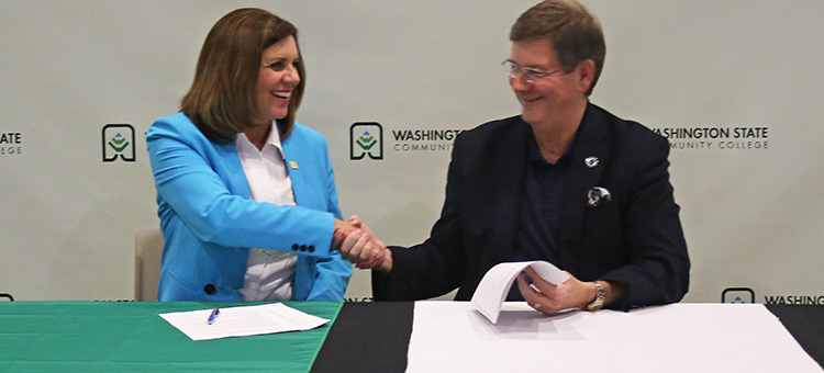 WSCC2MC agreement. WSCC President Dr. Vicky Wood shaking hands with Marietta College President Dr. William Ruud